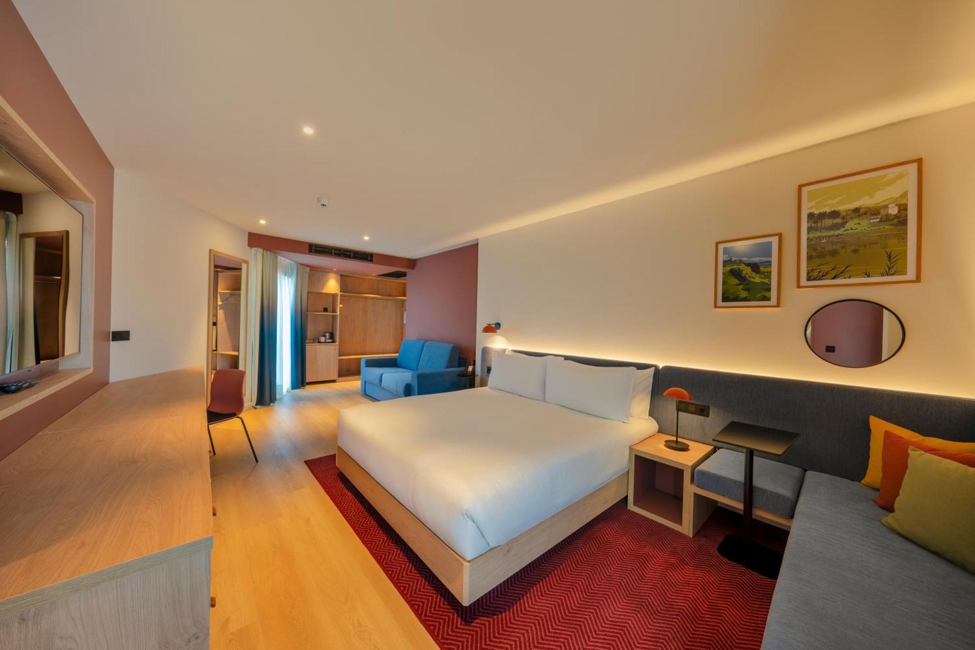 Habitación con cama extragrande y sofá cama